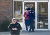 Betty Davis, 73, is led out of the Arvest Bank on Monday on Martin Luther King Jr. Boulevard in Fayetteville after the police and bomb squad were called to the bank after the woman reported she had been kidnapped and a bomb had been strapped to her ankle. She was led out of the bank after the device had been removed.