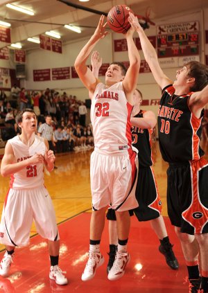 Chase Garner, Farmington junior center, takes a shot in the lane as Gravette sophomore forward Terence Pierce, right, tries to block Tuesday at Farmington High.