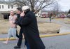 Jonathan Butler, left, is escorted by a police officer Thursday as an unidentified friend of Butler’s advises him to not resist arrest outside an apartment fire at 1780 West Holly St. in Fayetteville.
