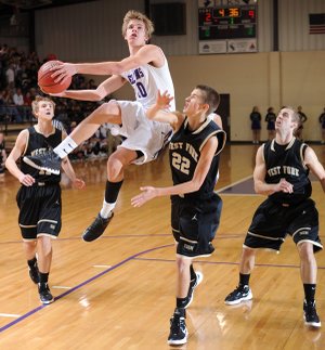 Elkins’ Spencer Jones, center, leaps to score as West Fork junior Trusten DeSoto, right, reaches to defend Friday at Elkins High School. Go to nwaonline.com/photoreprints to see more photos.
