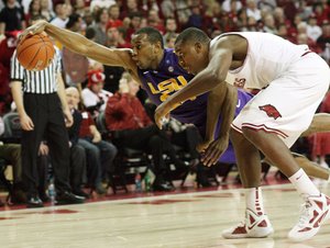 LSU forward Storm Warren (left) dives past Arkansas forward Devonta Abron for a loose during Saturday’s game at Walton Arena in Fayetteville. Arkansas won 69-60, improving to 13-4 on the season and 2-1 in SEC games. 