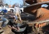 Brendan Hungate, left, and Braxton Leichner, employees with Multi-Craft Contractors, Inc., monitor a co-worker breaking up hard rock down in a 10-foot-deep hole Wednesday near the Shiloh Square in Springdale. A drill was able to dig most of the hole, but hard rock near the bottom made the crew work with a jackhammer to finish. Multi-Craft is going to install a 70-foot wind turbine to provide an alternative energy source for the Razorback Greenway that will pass through the spot. The turbine is being paid for by the Department of Energy.