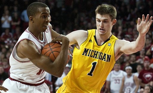Arkansas' BJ Young, left, drives to the basket against Michigan's Stu Douglass (1) during the first half of an NCAA college basketball game in Fayetteville, Ark., Saturday, Jan. 21, 2012. (AP Photo/April L. Brown)