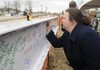 MAKING A MARK Ashley Ross, a student in NorthWest Arkansas Community College’s nursing program, signs the beam Friday to top out the college’s new Center for Health Professions building during a ceremony at the school in Bentonville. The 83,000-square-foot building is expected to be complete in spring 2013 and cost $14.2 million.
