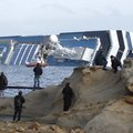 People stop and look at the grounded cruise ship Costa Concordia off the Tuscan island of Giglio, It...