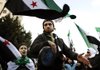 Anti-Syrian regime protesters carry revolutionary flags while performing a traditional dance during a protest outside the Arab League headquarters in Cairo on Sunday.


