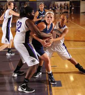 Caroline Eubanks, center, a Springdale Har-Ber senior post player, is tied up beneath the basket by Fayettevile junior post Brittany Austin, left, and sophomore guard Caylea Moore on Tuesday during the second half at Fayetteville High.