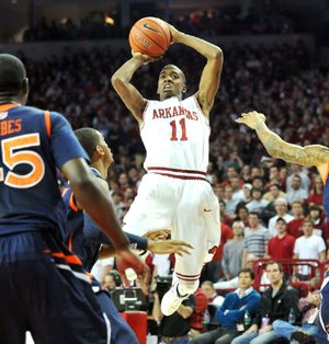 Arkansas guard BJ Young (11) pulls up for a shot over Auburn defenders on a fast break during the first half of the Razorbacks’ 56-53 victory Wednesday at Walton Arena in Fayetteville. Young led Arkansas with 11 points.