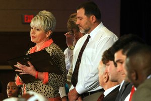 Michelle Uekman holds the Paul Eells Award, presented posthumously to her son, Garrett Uekman, as she speaks during Friday’s Little Rock Touchdown Club 2011 Awards Banquet in Little Rock. Michelle was joined by her daughter, Meagan (center), and husband, Danny.