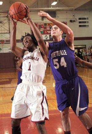 Jarvis Odems, left, a Springdale High senior, and Fayetteville junior Tyler McCullough battle for a rebound during the first half of Friday’s game at Springdale High.
