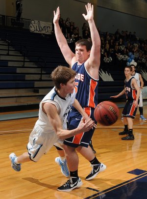 Alex Rice, left, a Springdale Har-Ber junior, passes around Rogers Heritage senior Blake Woodson (55) in the first half Friday in Wildcat Arena in Springdale.
