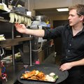 Assistant Manager Jared Lowrey calls out orders to chefs Friday at Tusk & Trotter in Bentonville dur...