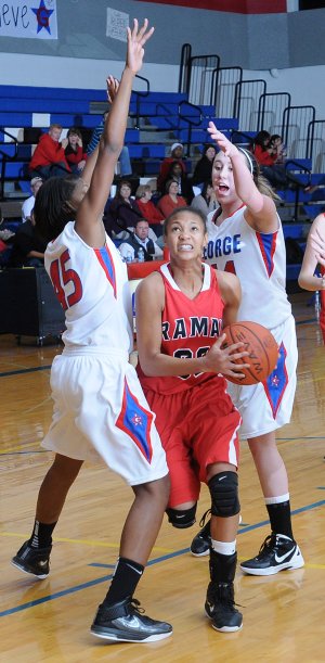 Fayetteville Ramay Junior High School’s DaShundra Morgan squeezes through Desiree Mack, left, and Ryann Goodsell, right, of George Junior High School Monday at George Junior High School in Springdale.