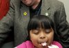 Jaquelin Troncoso, an Eastside first-grader, taste tests a cupcake with bubblegum flavored frosting in the sensory testing lab at the Sam’s Club Home Office in Bentonville on Monday. Helping Jaquelin with the test was Sam’s Club bakery buyer Paul Tichenor. Jaquelin was with a group of students from Eastside Elementary School in Rogers and Elm Tree Elementary School in Bentonville who were given a tour of the home office labs and kitchen facilities.