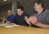 STAFF PHOTO FLIP PUTTHOFF -- Rogers Mounties offensive lineman Thomas Jespersen signs his Missouri Southern scholarship paperwork to the applause of his dad, Ron Jespersen, right, and Mounties offensive line coach Rob Bray.