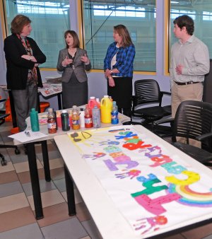 Kelly Kemp-McLintock, second from left, chief advancement officer for the Jones Center, speaks Wednesday to Karen Parker, from left, senior manager for the Walmart Foundation, Sarah Van Vleck, advancement coordinator for the Jones Center, and Evan Carver, a Jones Center intern, in the YOUth Center’s art room at the Jones Center. The Walmart Foundation presented the center with a $250,000 check to support youth programs, the YOUth Center and the Summer Youth Academy.