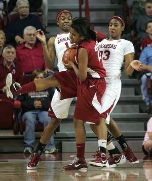 Arkansas Razorbacks forward Ashley Daniels (left) and guard Lyndsay Harris (right) defend against Alabama guard Khristin Lee during the first half of Thursday’s game at Bud Walton Arena in 