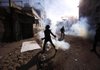 An Egyptian protester throws away a tear-gas canister fired by security forces Friday during clashes near the Interior Ministry in Cairo.