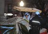 A U.S. Park Police officer removes a wooden structure from an Occupy DC protestor's tent at McPherson Square in Washington, Saturday, Feb. 4, 2012. Park Police arrived before dawn to enforce a no camping law at the square near the White House. The regulations permit protesters to remain onsite at all hours with tents, but bars them from camping or laying down bedding material.