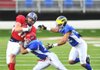 South Squad tight end Phillip Supernaw (left) of Ouachita Baptist is tackled by North Squad safety Chad Falcon of Montclair State (center) and Troy Woolfork of Michigan during the second quarter of the Players Classic All-Star game Saturday at War Memorial Stadium in Little Rock. 
