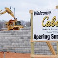 A sign displays the opening date of a new store Tuesday as construction crews work at the Cabela’s c...
