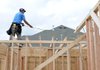 Christian Juares from Cox Development measures the length between beams on a house Tuesday at 3735 Rock Springs St. in Springdale.
