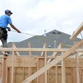 Christian Juares from Cox Development measures the length between beams on a house Tuesday at 3735 R...