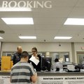 Benton County Sheriff’s Office deputies Tiffany Bowman, center, and Hunter Ayre, left, process an in...