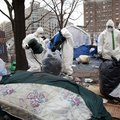 Workers in protective gear remove tents, camping gear and debris left by Occupy DC protesters in McP...