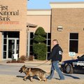 A K-9 unit begins a search for a suspect in a bank robbery at the First National Bank of Centerton M...