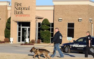 A K-9 unit begins a search for a suspect in a bank robbery at the First National Bank of Centerton Monday Feb. 6, 2012 in Centerton.