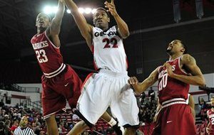 Georgia guard Gerald Robinson (22) shoots a lay up while defended by Arkansas guard Julysses Nobles (23), left, and Arkansas guard Rashad Madden (00) during the first half of an NCAA college basketball game on Wednesday, Feb. 8, 2012, in Athens, Ga. (AP Photo/The Athens Banner-Herald, AJ Reynolds)