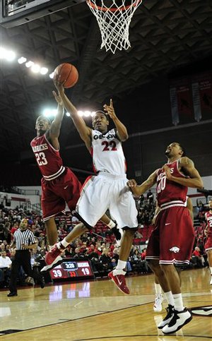 Georgia guard Gerald Robinson (22) shoots a lay up while defended by Arkansas guard Julysses Nobles (23), left, and Arkansas guard Rashad Madden (00) during the first half of an NCAA college basketball game on Wednesday, Feb. 8, 2012, in Athens, Ga. (AP Photo/The Athens Banner-Herald, AJ Reynolds)
