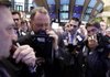 Robert Moran (center) huddles with fellow traders Wednesday on the floor of the New York Stock Exchange. 