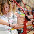SHARP FOCUS Jozie Crouch, 10, readies an arrow Thursday during a physical education class at Butterf...