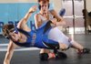 Logan Evans, right, Rogers Heritage, and Rogers High’s Chris Ogle compete in the championship bout for the 138-pound division Saturday during the 7A-West Conference wrestling meet at Har-Ber High School in Springdale.