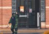Little Rock Fire Department bomb technician Ryan Baker signals Friday to other bomb-squad members that they can approach a U.S. Bank branch after a bank robber left a backpack containing what he said was a bomb in the building’s doorway. No explosives were found. 