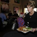 Gena Porter serves lunch Wednesday at Tusk & Trotter American Brasserie in downtown Bentonville.
