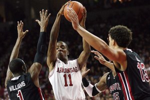 Arkansas guard BJ Young (11) splits South Carolina defenders Brenton Williams (1), Anthony Gill (13) and Malike Cooke (15) in the first half of the Razorbacks’ 76-65 victory Saturday in Fayetteville. Young had a game-high 27 points for Arkansas.