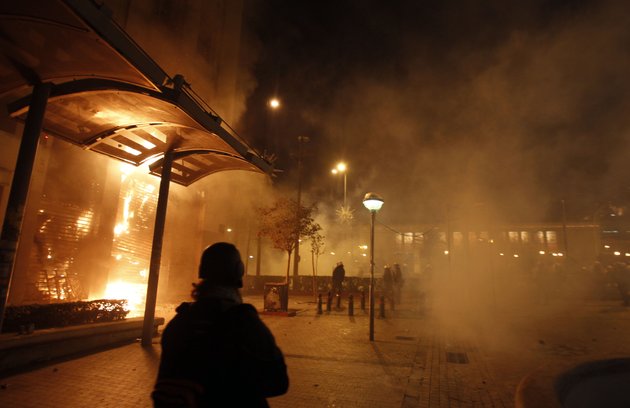 a-branch-of-eurobank-burns-during-clashes-in-athens-sunday-feb-12-2012-protesters-and-police-fought-in-central-athens-sunday-as-greek-lawmakers-debated-legislation-that-would-introduce-severe-austerity-measures-to-stave-off-bankruptcy
