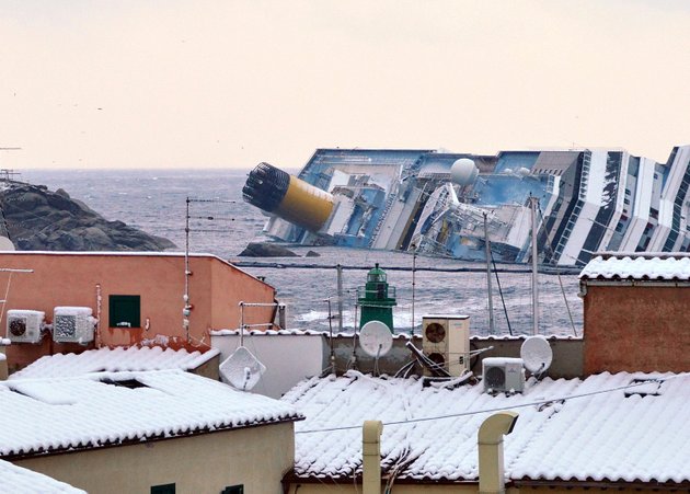 snow-covers-the-rooftops-of-the-houses-overlooking-the-harbor-of-the-tuscan-island-of-giglio-italy-saturday-feb-11-2012-as-the-costa-concordia-cruise-liner-remains-grounded-the-concordia-ran-aground-on-jan-13-after-the-captain-deviated-from-his-planned-route-and-gashed-the-hull-of-the-ship-on-a-submerged-reef