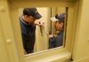 FINISHING TOUCHES Lance Hicks, left, with Southwestern Communication of Decatur, Ala., and James Frazier, with Sweeper Metal of Drumright, Okla., work on a detention door Thursday at Benton County’s new Juvenile Justice Center in Bentonville. Crews were finishing work and began moving into the facility Thursday.
