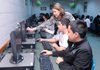 Christina Herbold, top, College Bound sponsor, points out to Sammy Hernandez, 12, center, and Raymundo Vargas, 12, what hyperlinks they need to click on Wednesday at Helen Tyson Middle School in Springdale during an exercise to estimate annual salary income for the lifestyles kids choose.