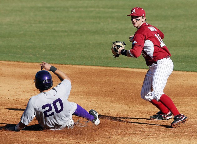 arkansas-democrat-gazettewilliam-moore-arkansas-shortstop-tim-carver-holds-his-throw-to-first-as-northwestern-states-nick-hinojos-slides-into-second-to-break-up-a-double-play-tuesday-february-21-2012-at-baum-stadium-in-fayetteville