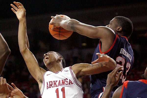 Mississippi’s Reginald Buckner blocks a shot by Arkansas’ BJ Young in the first half Tuesday in Fayetteville. Buckner had three of the Rebels’ seven blocks in a 77-75 victory. 