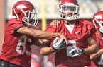 University of Arkansas receivers Maudrecus Humphrey (left) and Julian Horton run drills during the Razorbacks first spring practice at Razorback Stadium in Fayetteville.