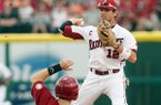 Arkansas second baseman Bo Bigham turns a double play at second over Alabama’s Jared Reaves during Sunday’s game at Baum Stadium in Fayetteville. 