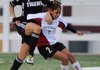 Martha Trujillo, right, of Springdale High, holds back Bentonville’s Paige Theilbar from getting to the ball Friday at Bulldogs Stadium in Springdale. 