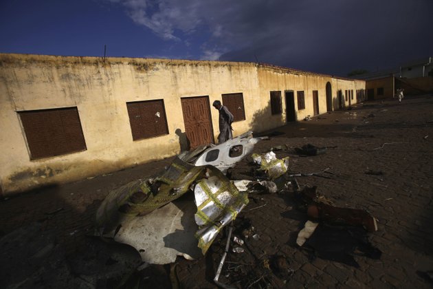 a-pakistani-man-walks-by-the-wreckage-of-a-bhoja-air-boeing-737-passenger-plane-that-crashed-on-friday-killing-all-127-people-on-board-on-the-outskirts-of-islamabad-pakistan-sunday-april-22-2012-pakistan-barred-the-head-of-the-airline-whose-jet-crashed-near-the-capital-from-leaving-the-country-vowing-to-investigate-the-tragedy-that-revived-fears-about-the-safety-of-aviation-in-the-country-saddled-by-massive-economic-problems
