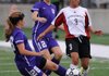 Blanca Barroso of Springdale High, right, takes the ball down field as Ashley Davidson, left, of Fayetteville watches as her teammate slides between the ball Thursday at Bulldog Stadium. 